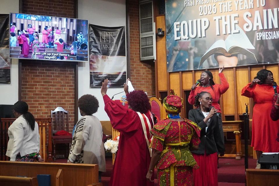 Members raising their hands as the worship singers lead