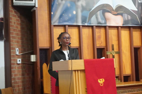 A reader standing at the wooden lectern