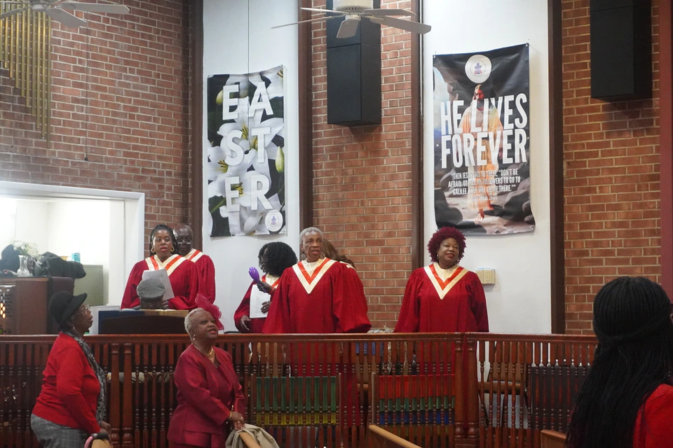 The robed choir standing in the choir stalls