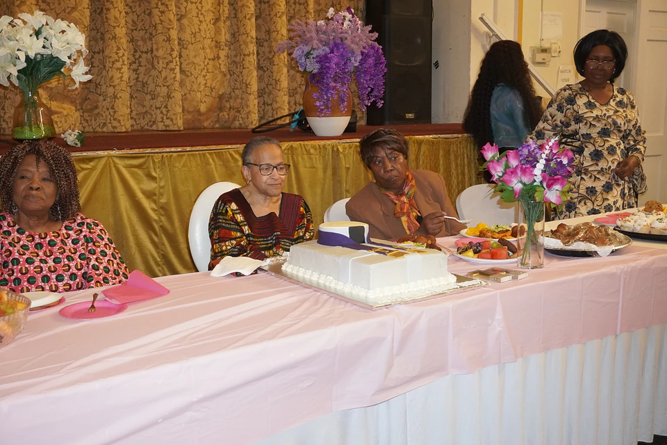 Members sharing a celebration around a decorated table