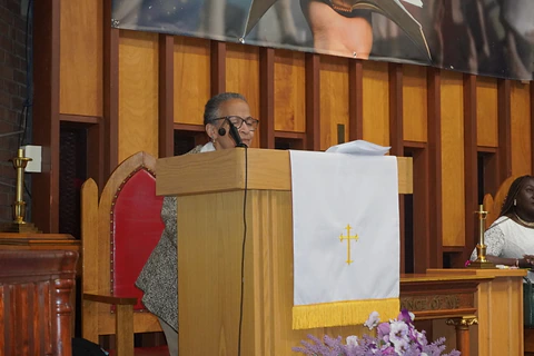 A reader at the pulpit beside the sanctuary cross