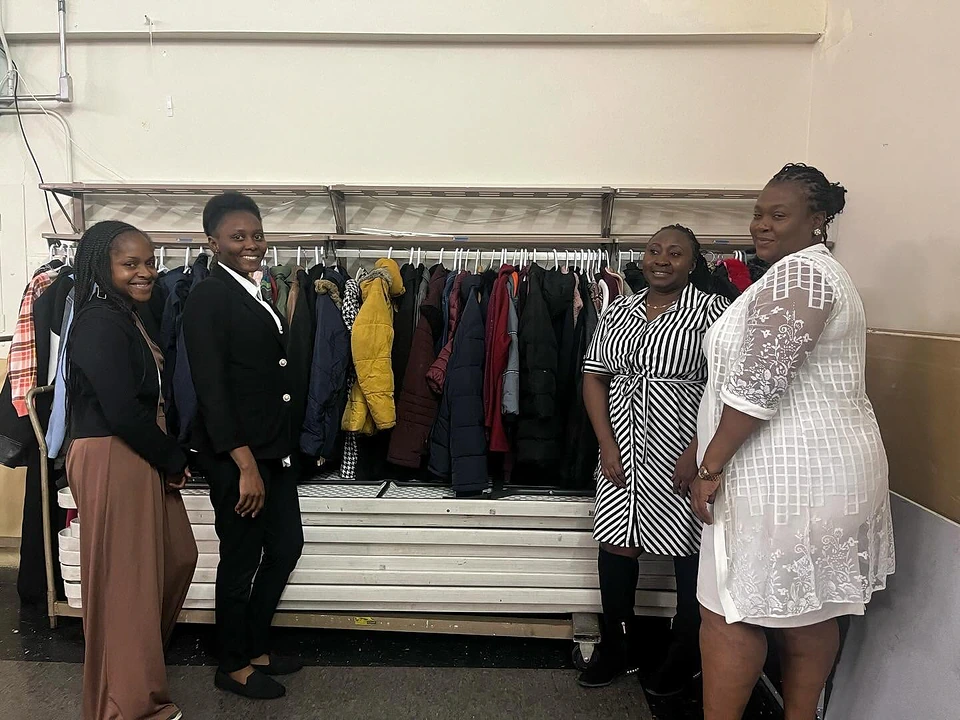 Church members gathered beside a clothing rail for community service