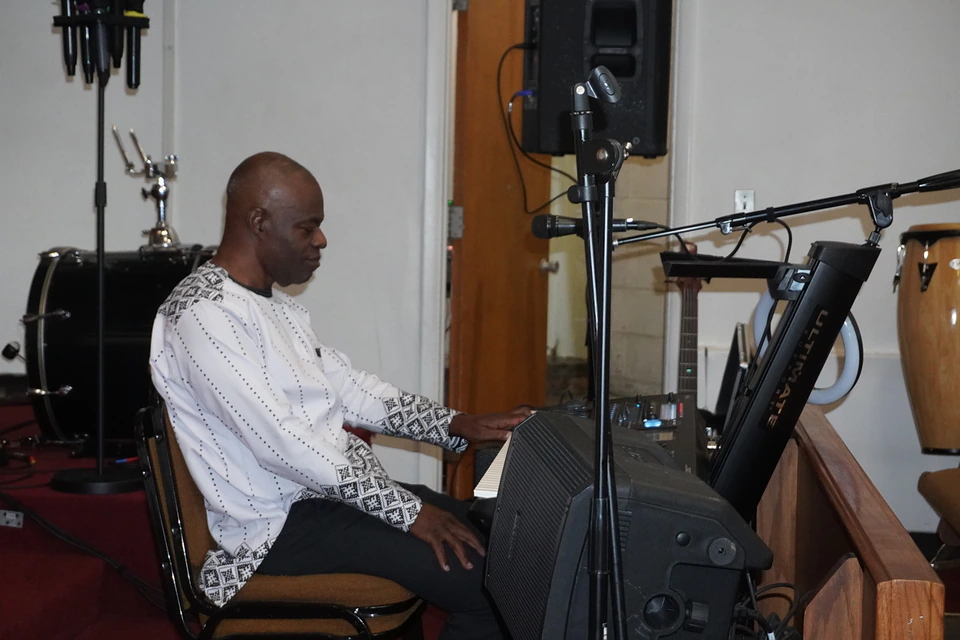 A keyboard player preparing music beside the percussion instruments