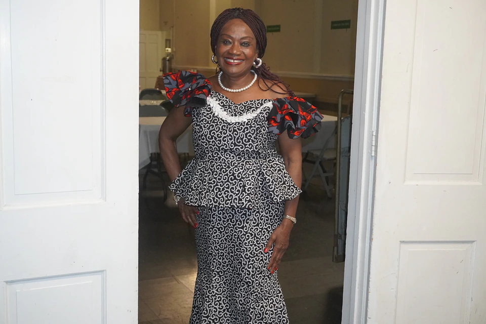 A church member welcoming the camera near an open doorway