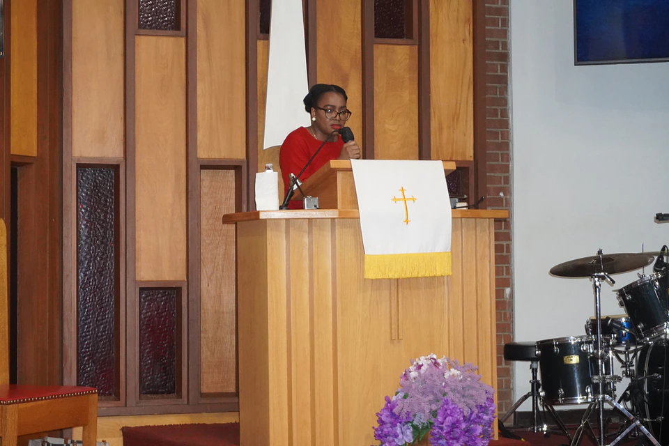 A speaker reading from the pulpit during worship