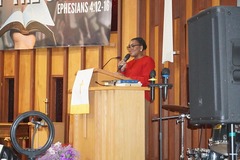 A speaker reading at the pulpit during the service